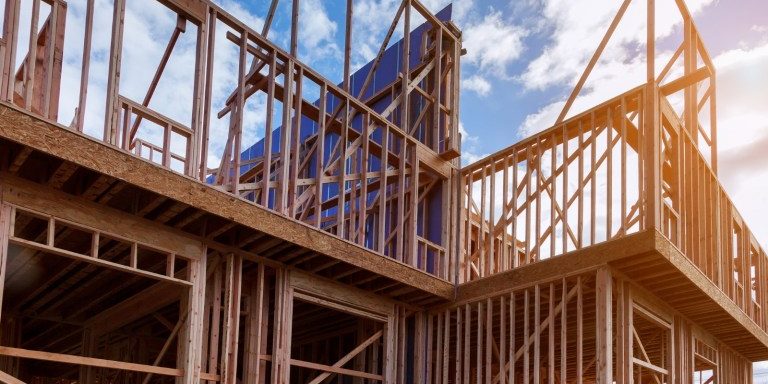 new-house-under-construction-framing-against-a-blue-sky-picture-id1135653561